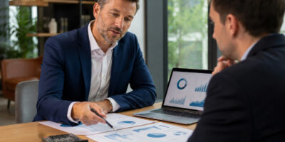 Consulenti analizzano grafici finanziari per la valutazione dell’EBITDA normalizzato di una PMI